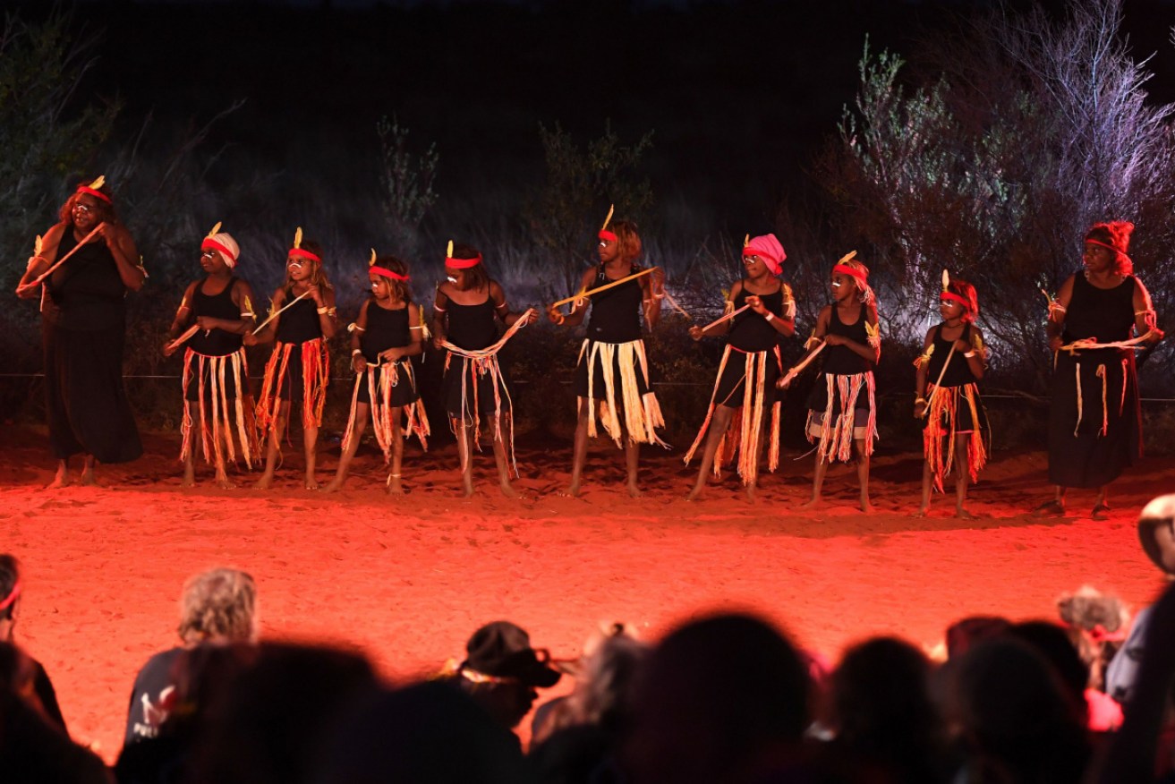 Indigenous Anangu perform during a ceremony marking the permanent ban on climbing Uluru.