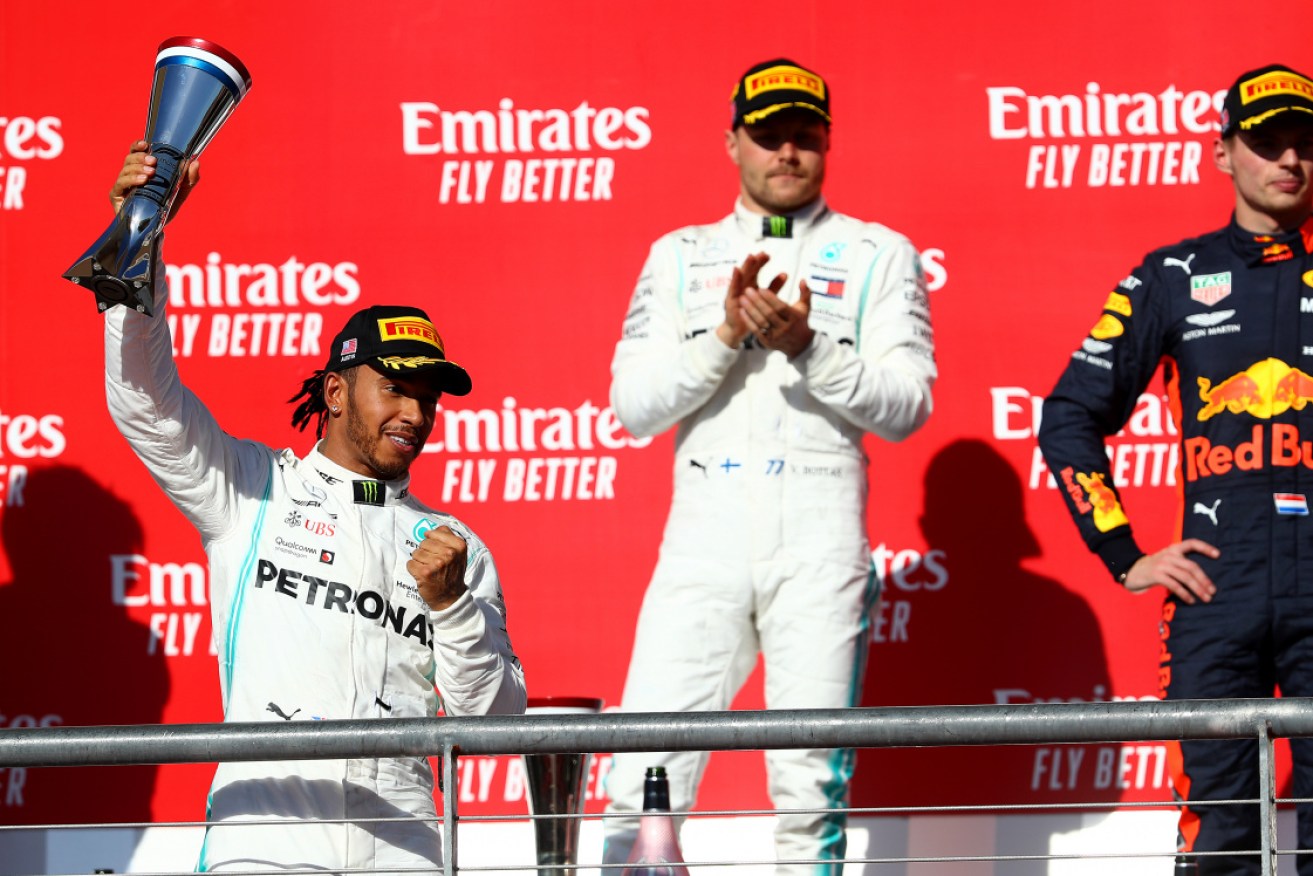 Formula One world champion Lewis Hamilton celebrates on the podium at the USA Grand Prix.
