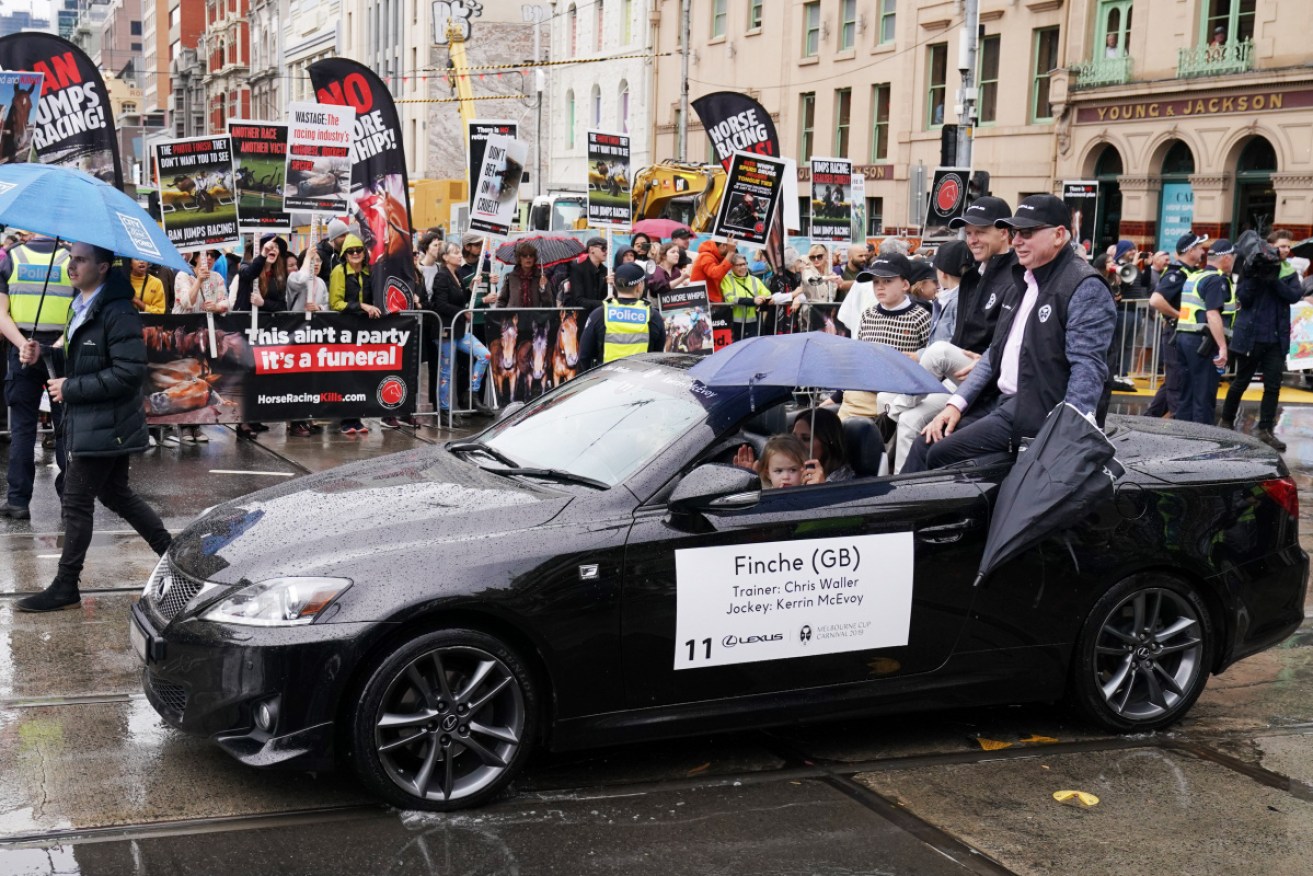 Thousands of people have braved wet weather to attend the annual Melbourne Cup parade, including hundreds of protesters.