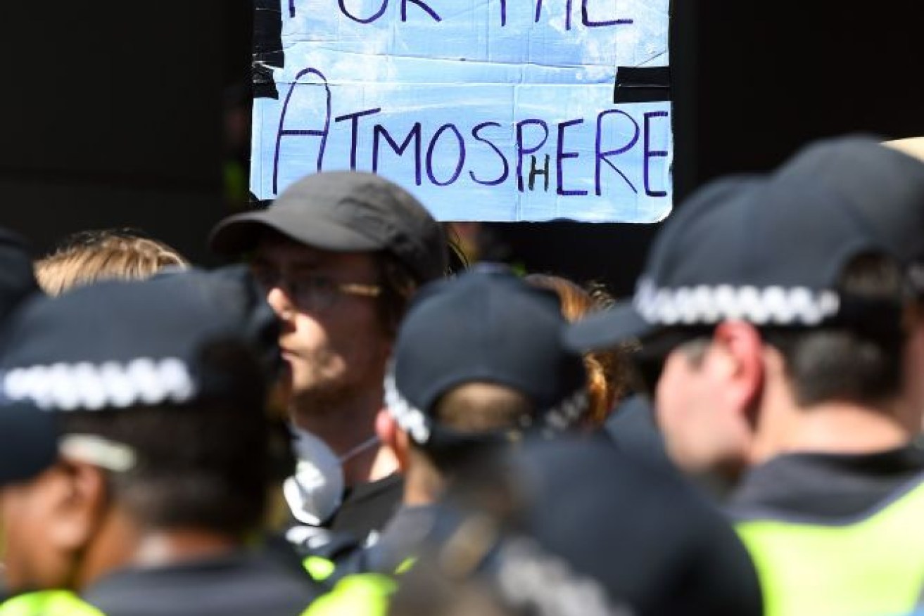 A protester holds up a placard as they attempt to blockade the International Mining and Resources Conference held in Melbourne in October.