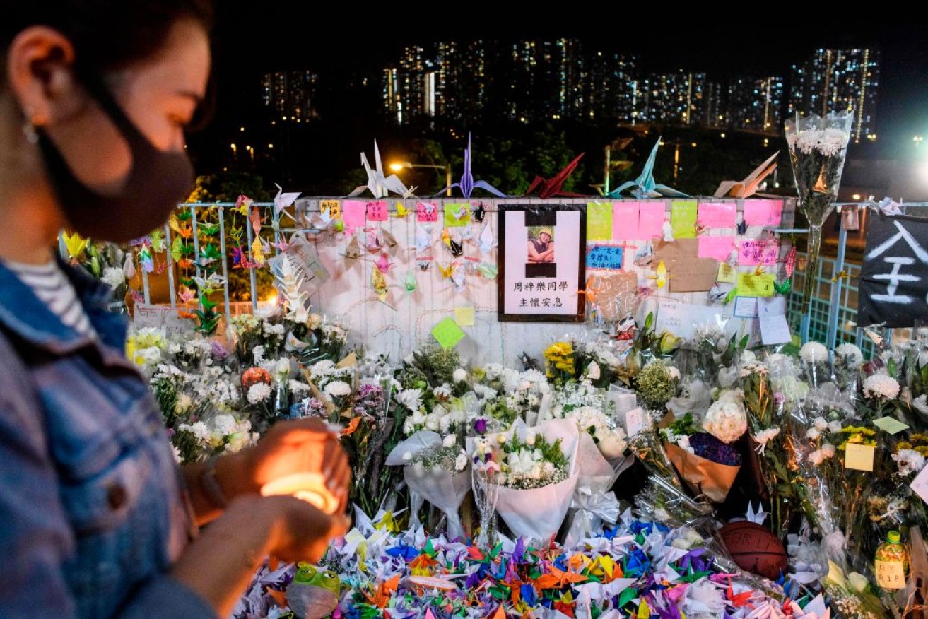 A mourner pays her respects at the site where student Alex Chow, 22, fell during a recent protest in Hong Kong.
