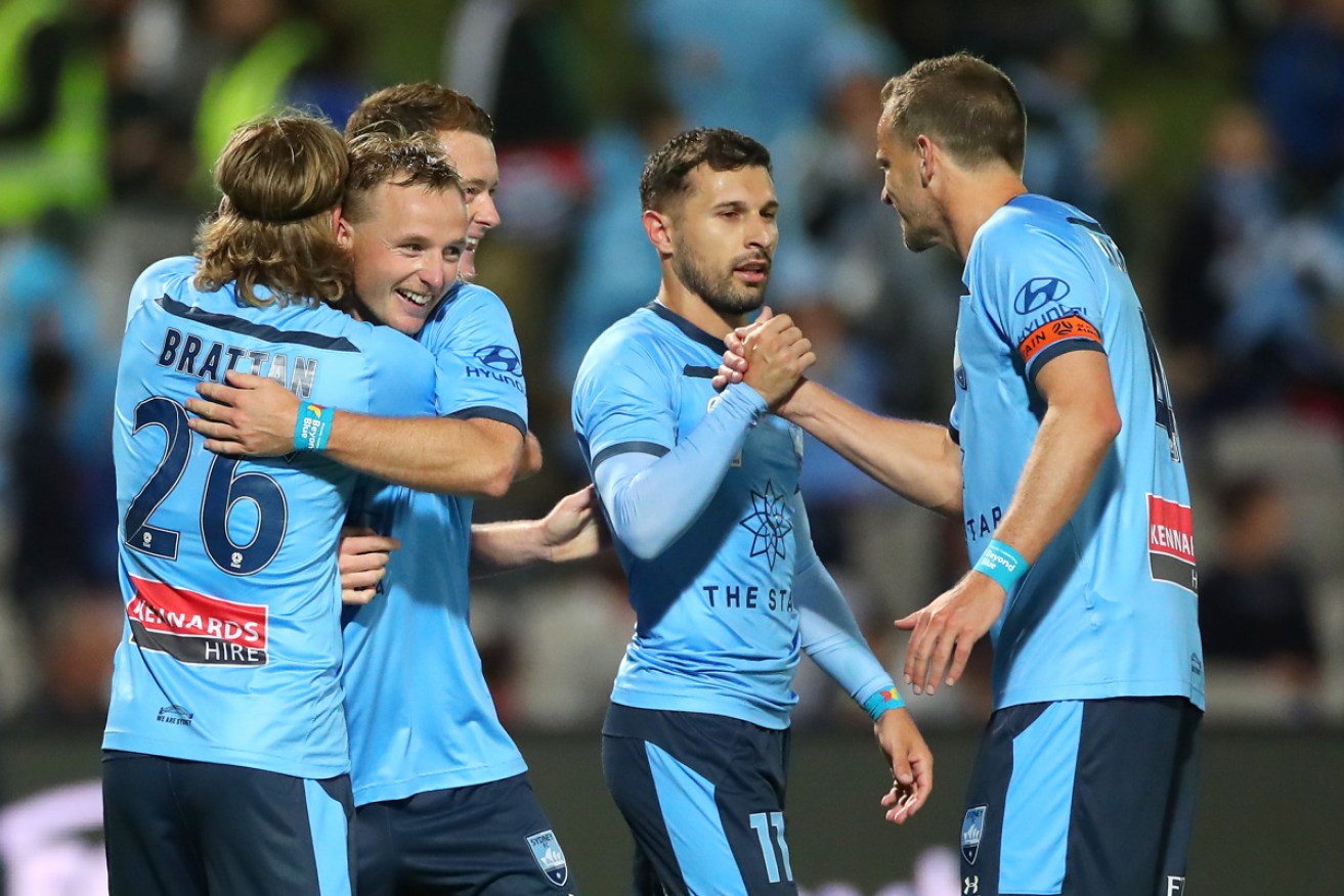 Sydney FC players celebrate after Kosta Barbarouses scored the winning goal.