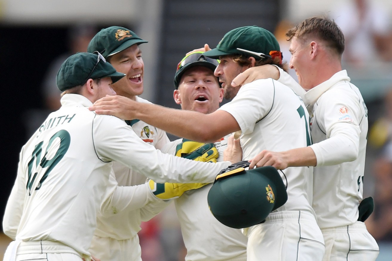 The Australians celebrate after winning the first Test at the Gabba, 