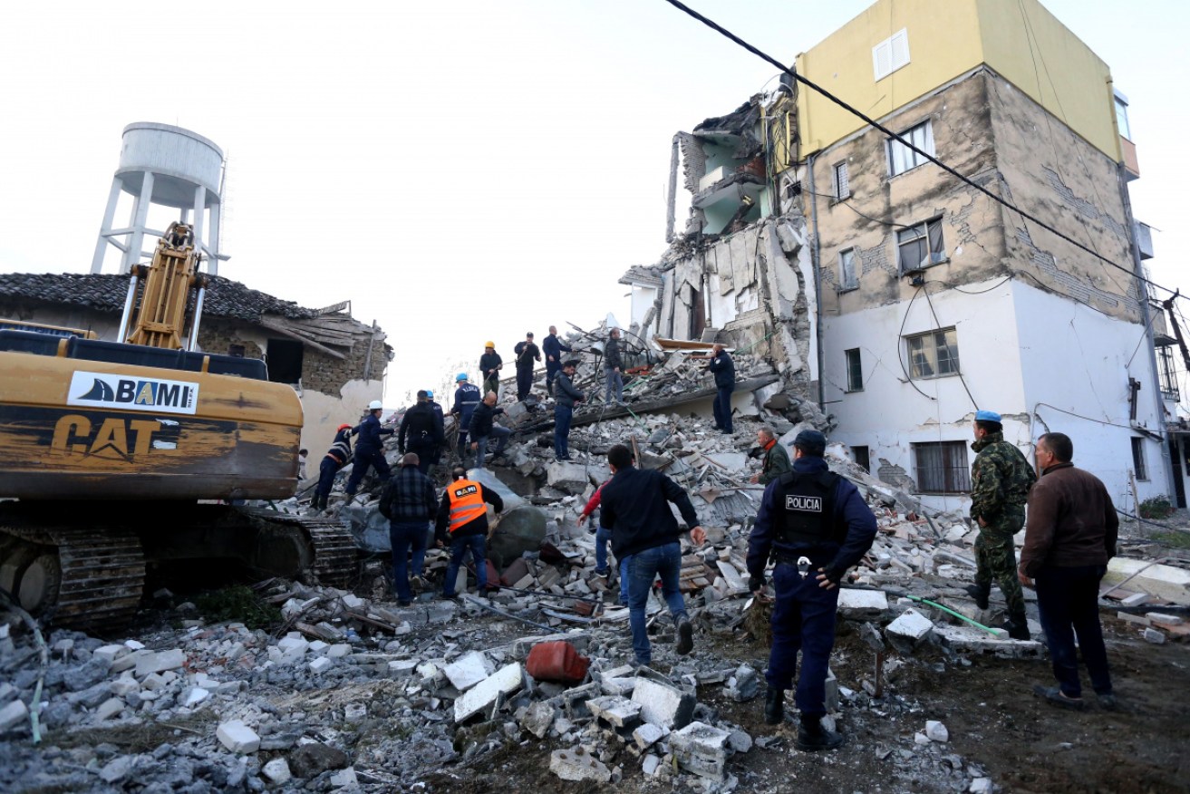 Emergency workers clear debris at a damaged building in Thumane, 34 kilometres (about 20 miles) northwest of capital Tirana, after an earthquake hit Albania, on Tuesday. 