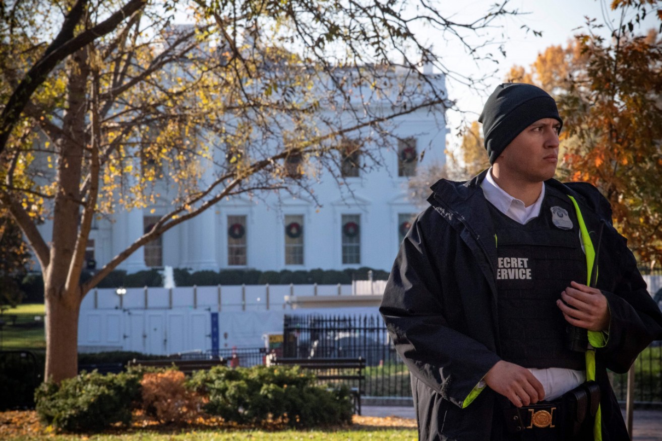 A uniformed Secret Service officer patrols the grounds at the White House in Washington, DC.