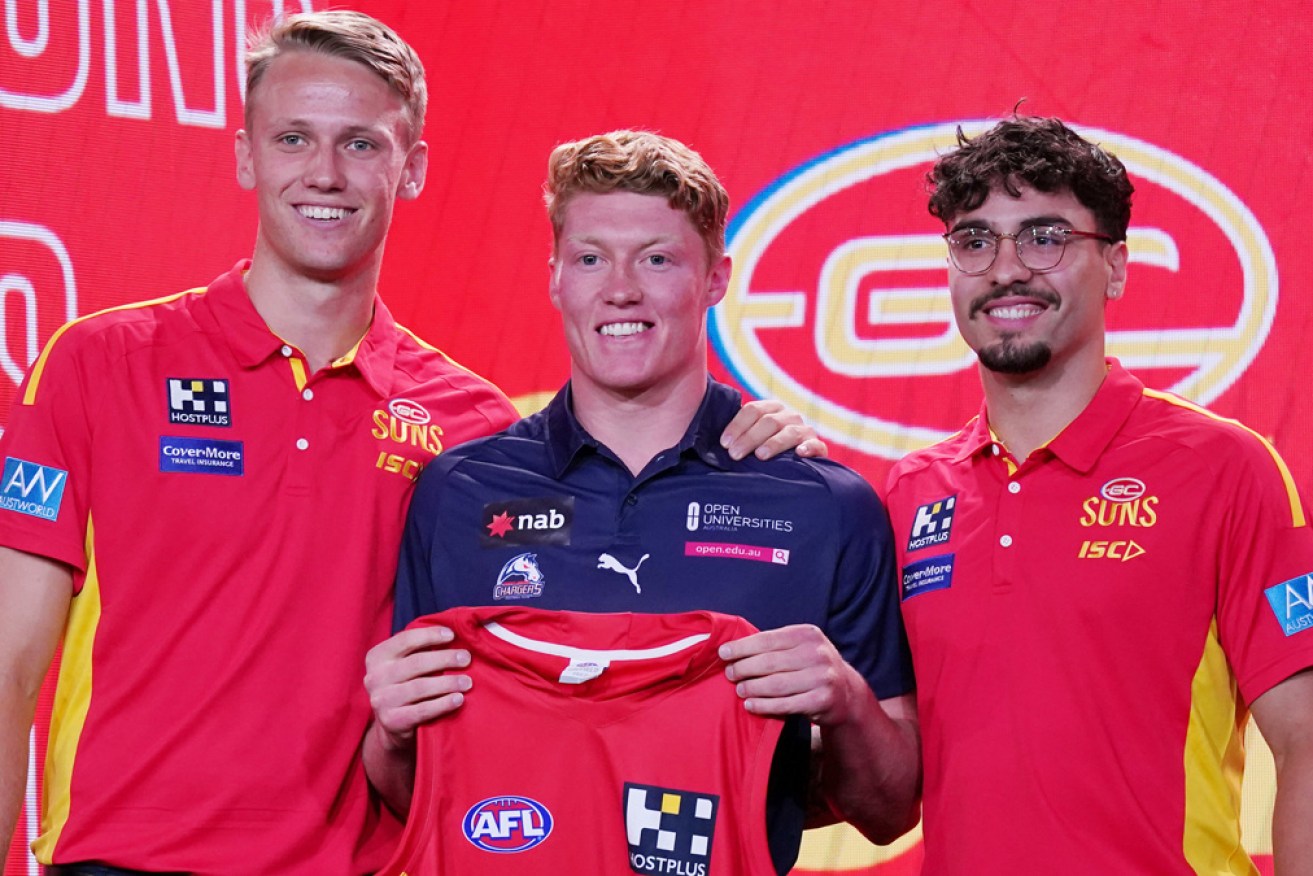 Matt Rowell (centre) is presented with his Gold Coast jersey at the 2019 AFL Draft in Melbourne on Wednesday.