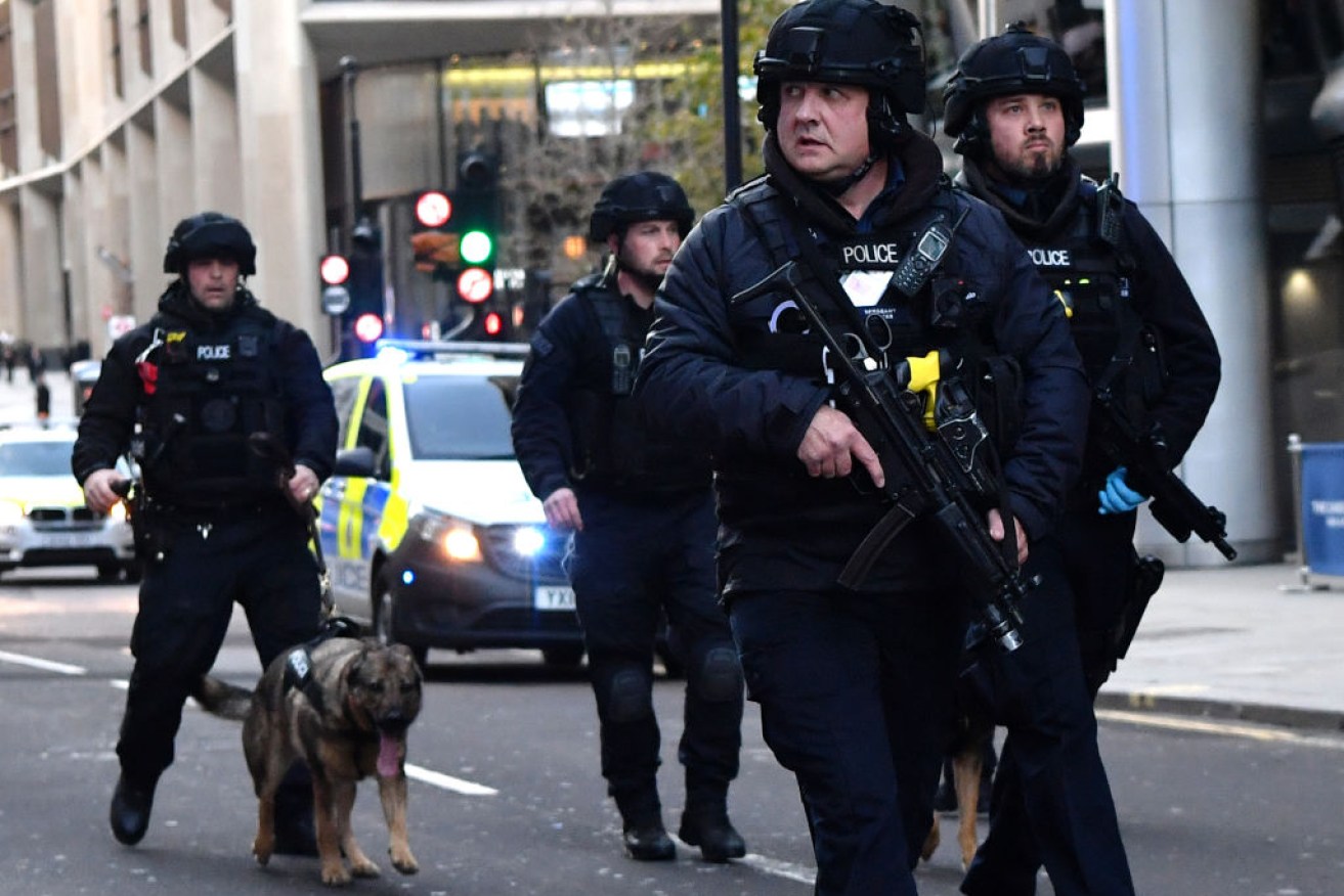 Armed police with dogs patrol Cannon Street in central London after a terror suspect went on a knife rampage and was shot dead by police.