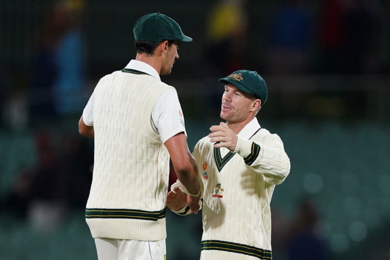 The destroyers: Mitchell Starc and David Warner embrace at stumps. 