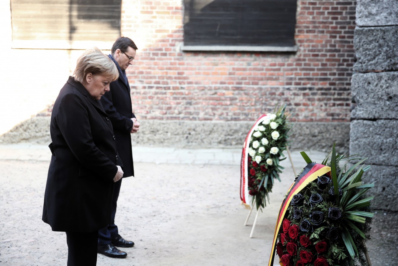 German Chancellor Angela Merkel and Polish Prime Minister Mateusz Morawiecki (R) lay a wreath at the Death Wall during a visit to the Auschwitz-Birkenau Memorial and Museum.