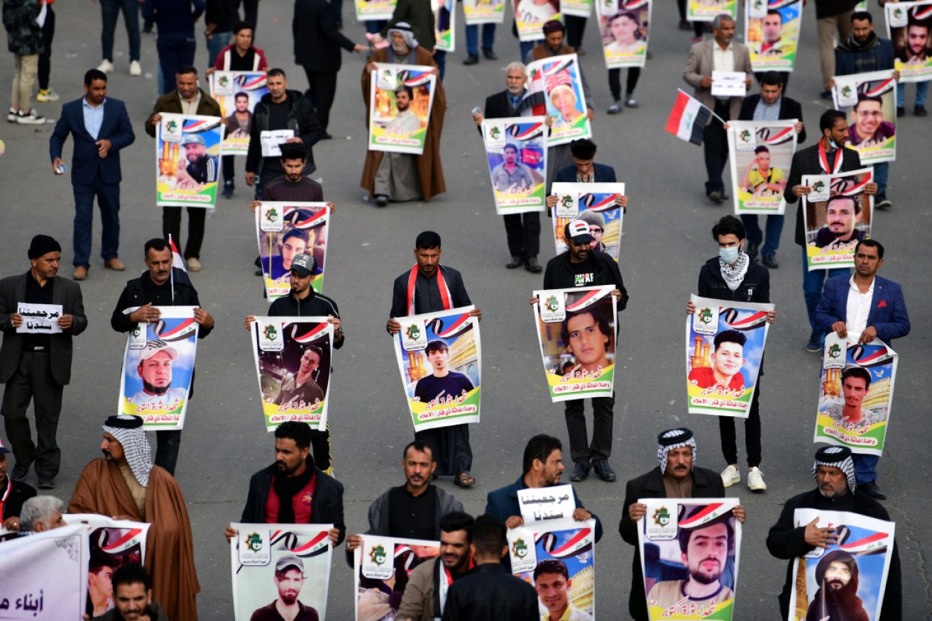Supporters of Iraqi Shiite group Popular Crowd Forces and spiritual leader Grands Ali al-Sistani carry the pictures of the victims of protests.