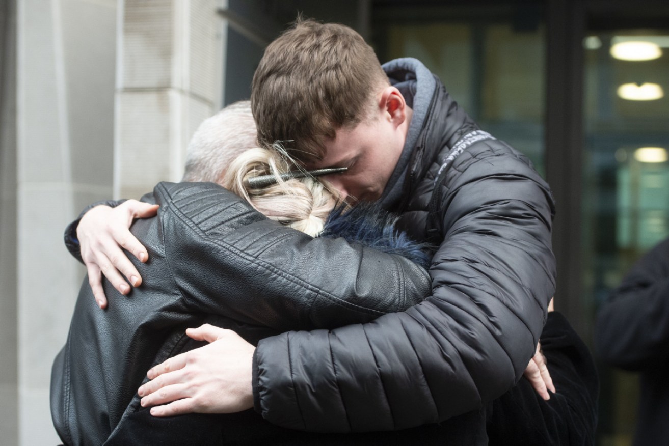 Harry Dunn mother Charlotte Charles (centre), stepfather Bruce Charles (left) and friend Isaac Seiger hug outside the Ministry Of Justice.