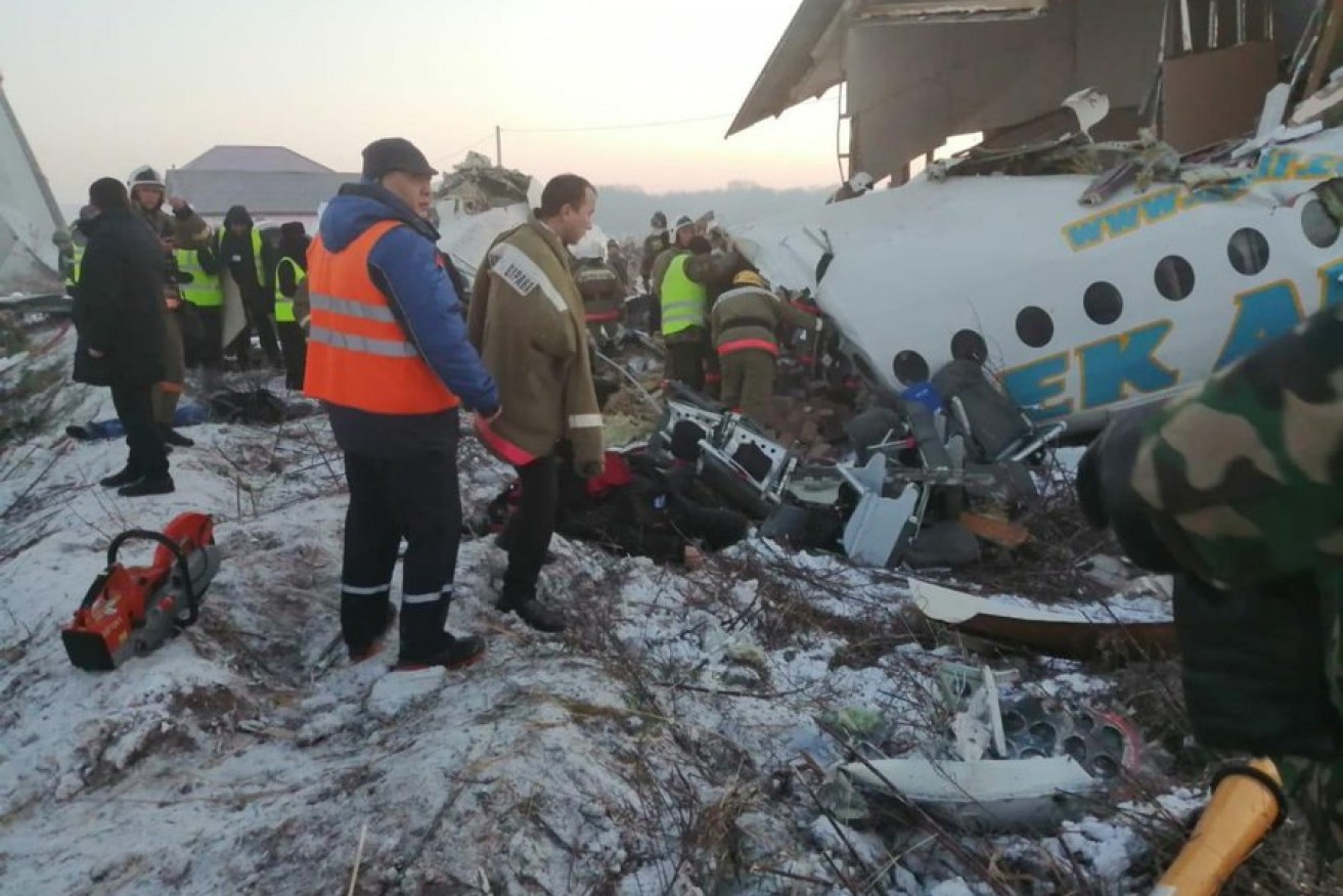 Rescuers and bystanders observe the wreckage of a Bek Air flight which has crashed in Kazakhstan. 