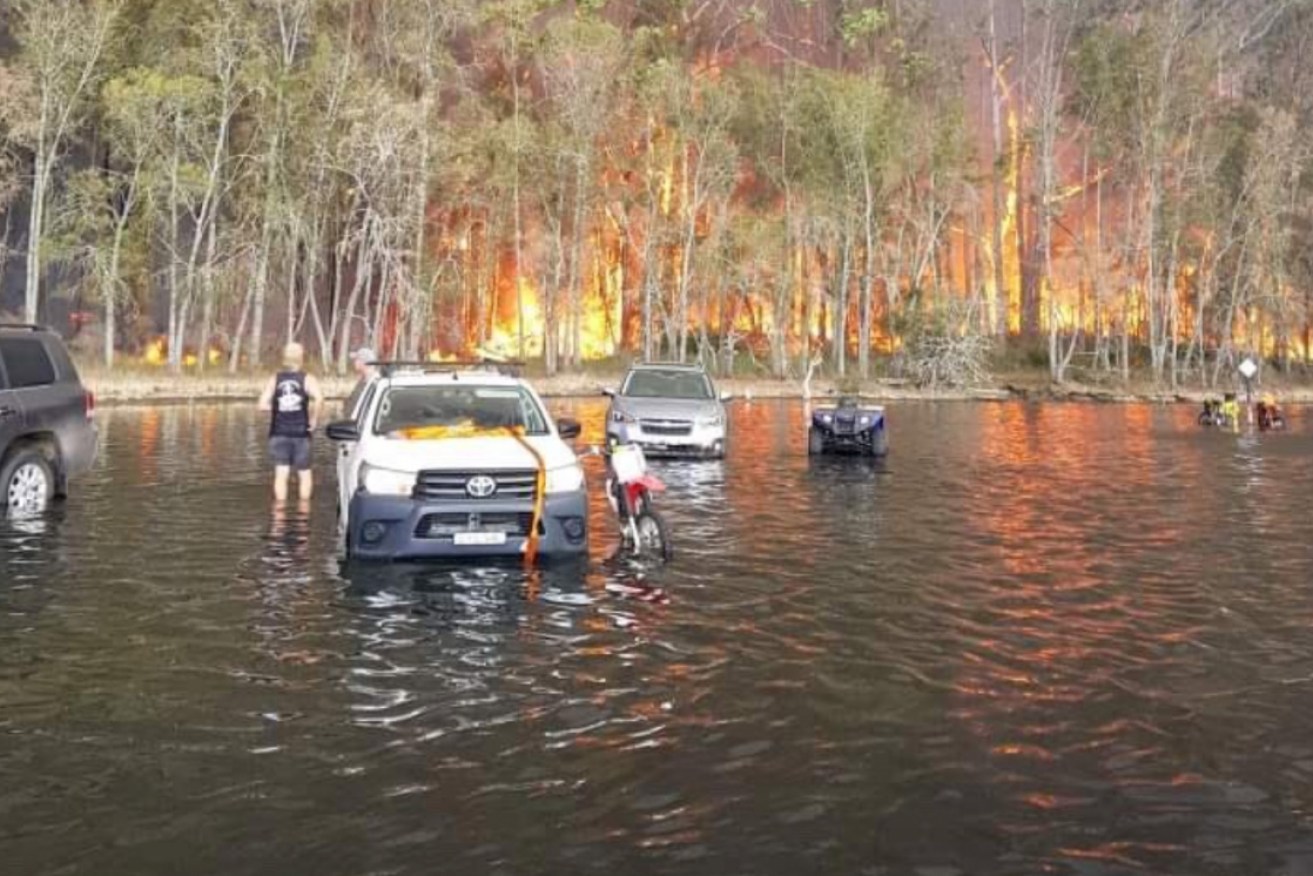 Vehicles were seen driving into water at Lake Conjola to avoid the flames.