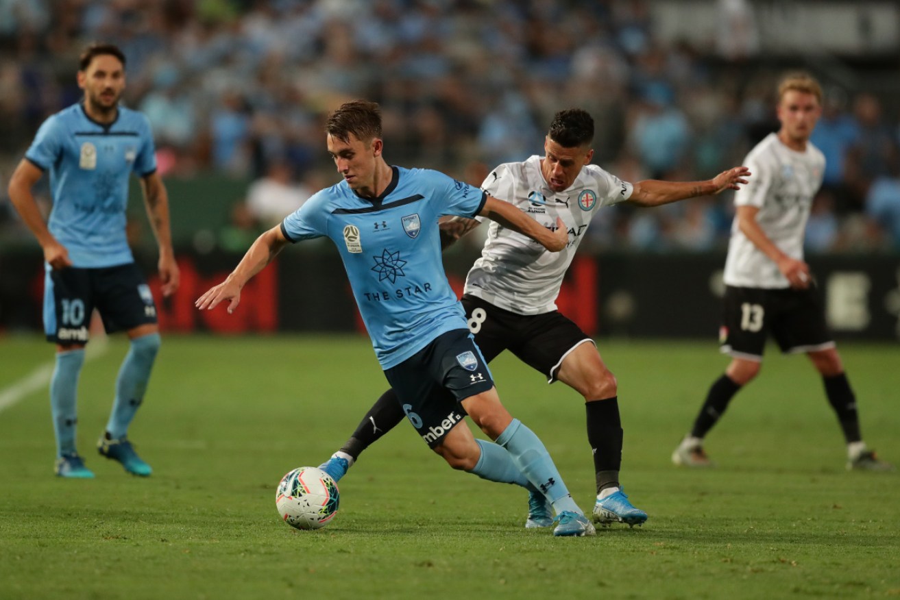 Sydney's Ryan Mcgowan takes on Melbourne City's Javier Cabrera.