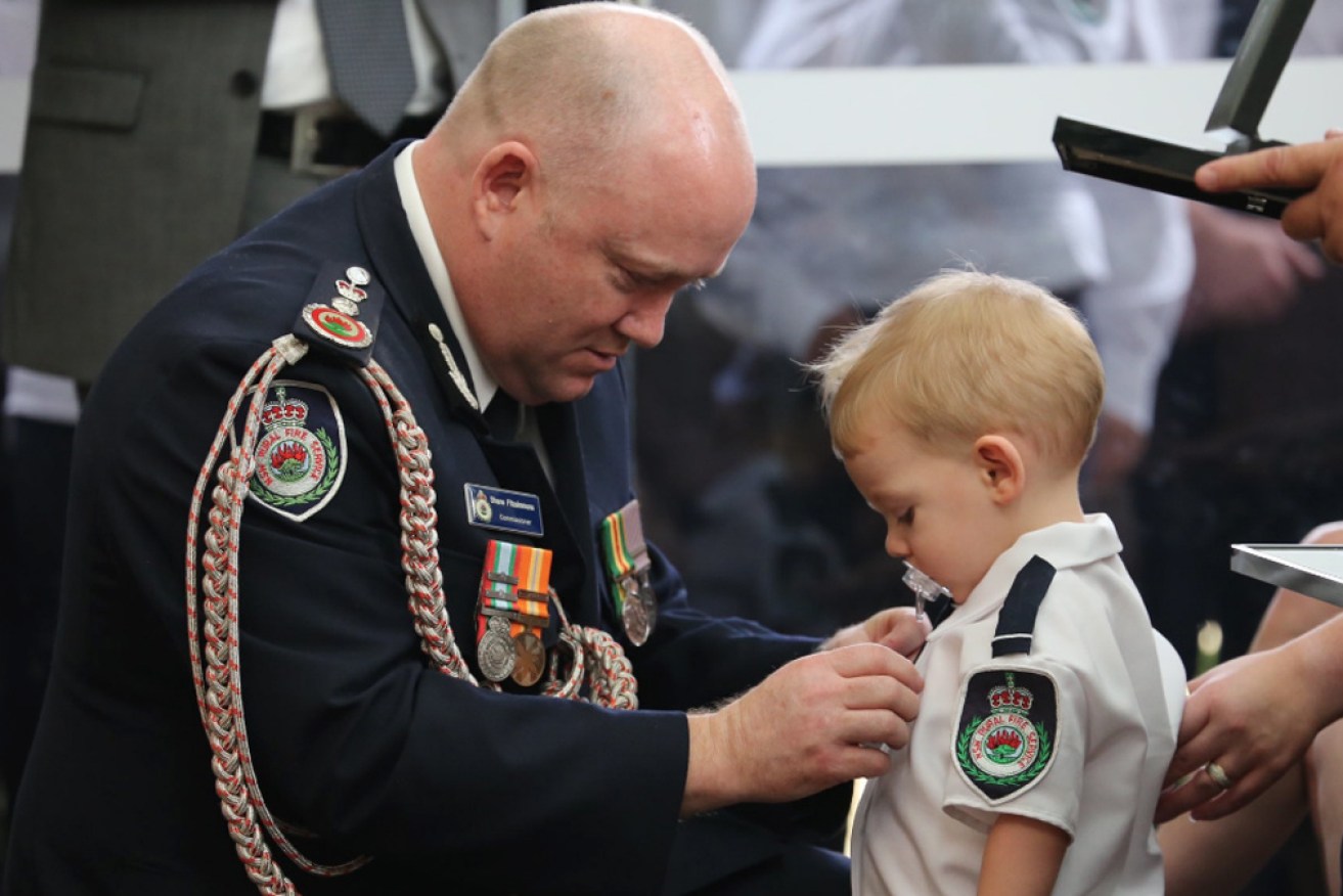 NSW RFS commissioner Shane Fitzsimmons with Geoffrey Keaton's young son Harvey.
