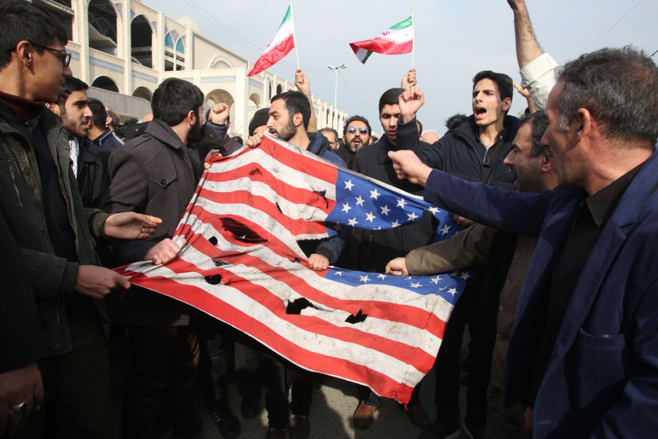 Iranians tear up a US flag during a demonstration in Tehran following the killing of the Iranian Revolutionary Guard's Major General Qasem Soleimani in a US strike.