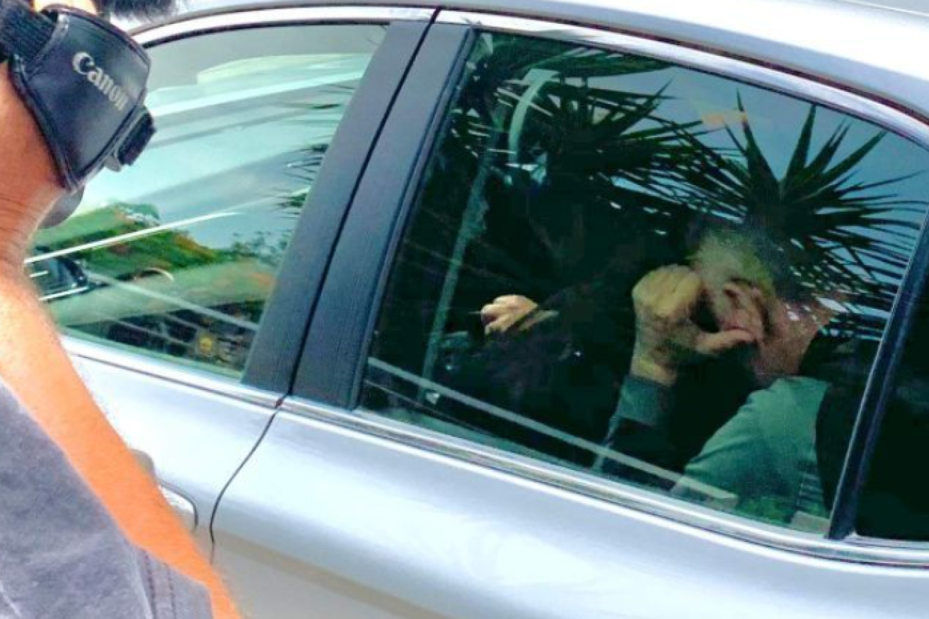 Warren John McCorriston buries his face in his hands outside Court