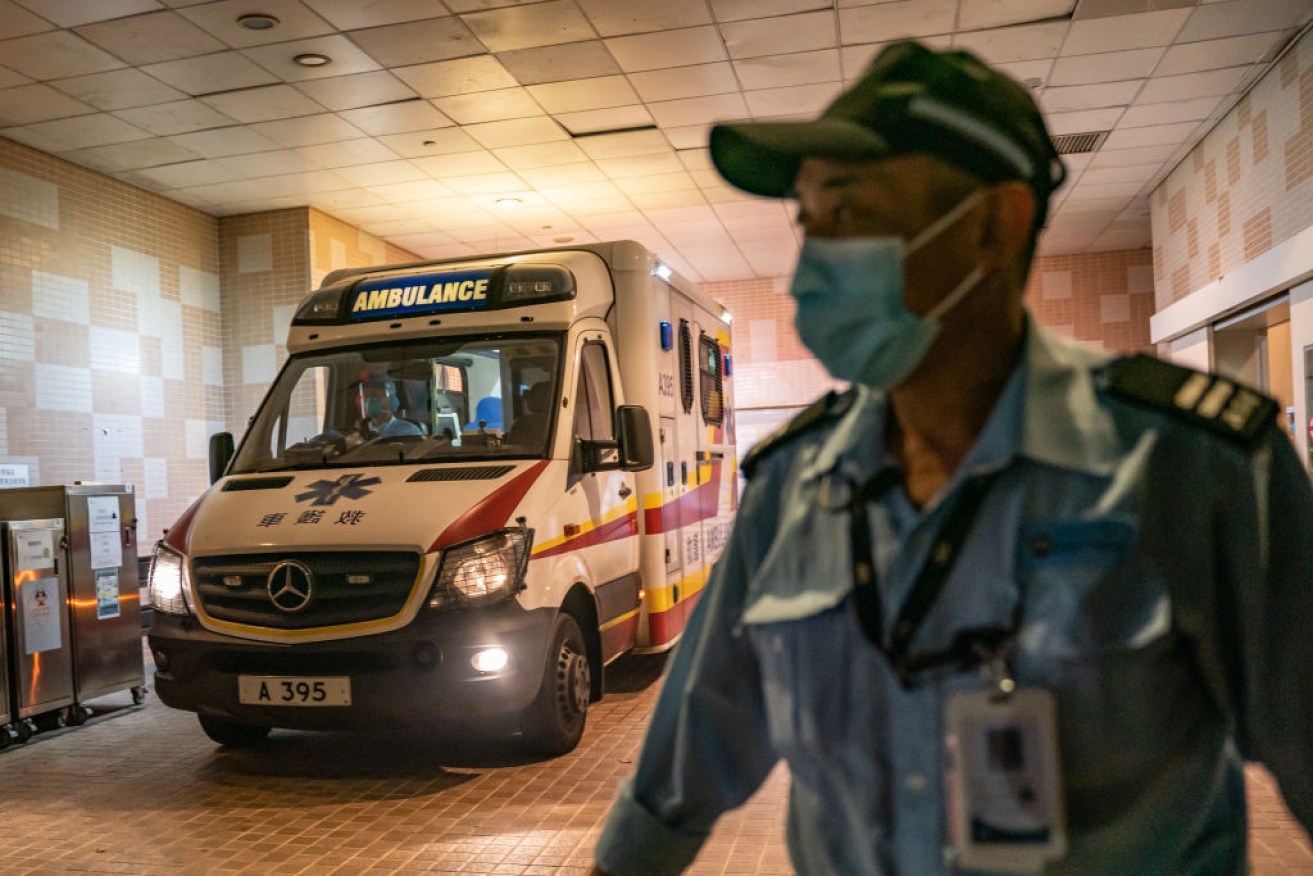 A security official stands guard as an ambulance arrives at the Infectious Disease Centre of Princess Margaret Hospital in Hong Kong.