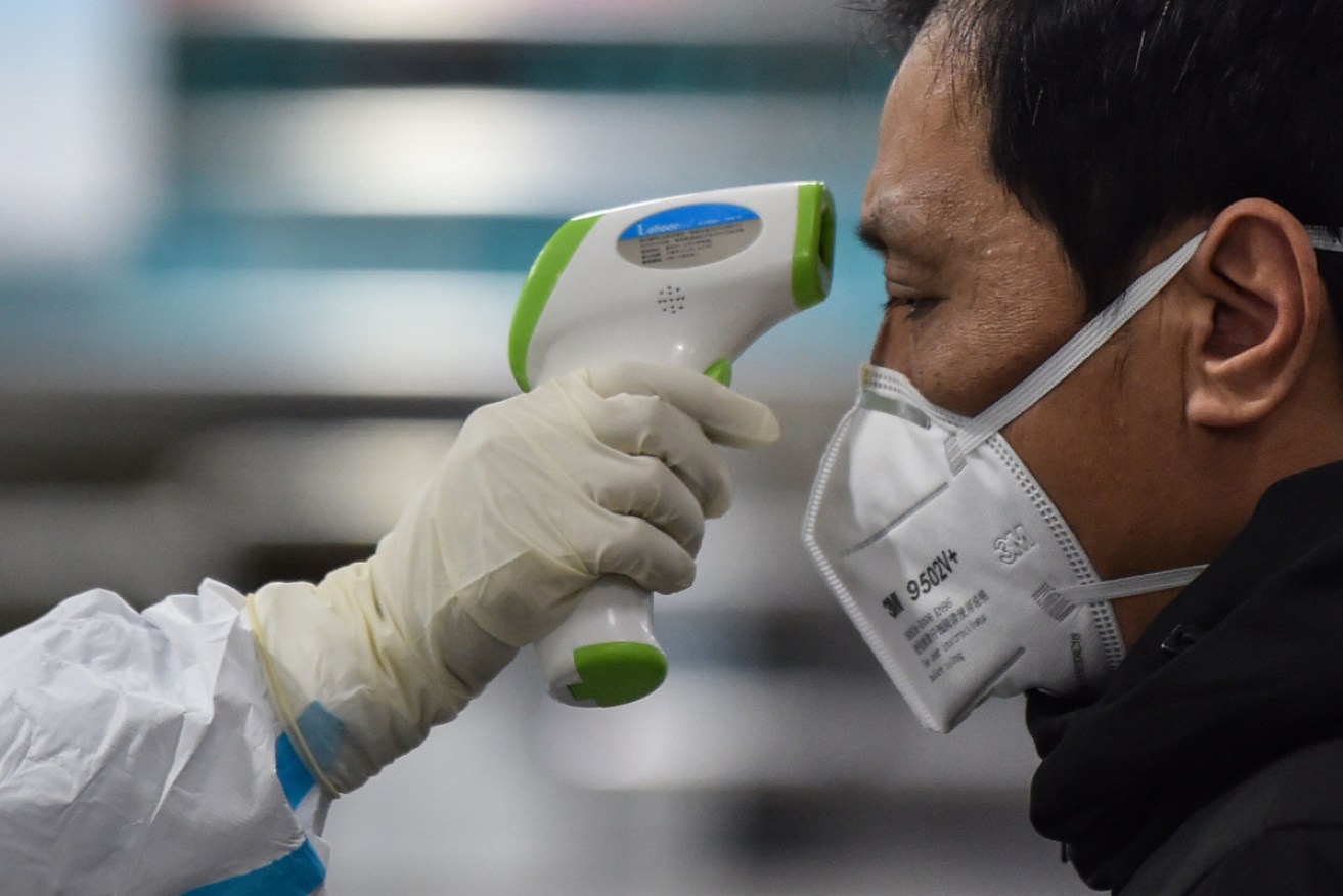 A man at the Wuhan Red Cross Hospital has his temperature taken. 