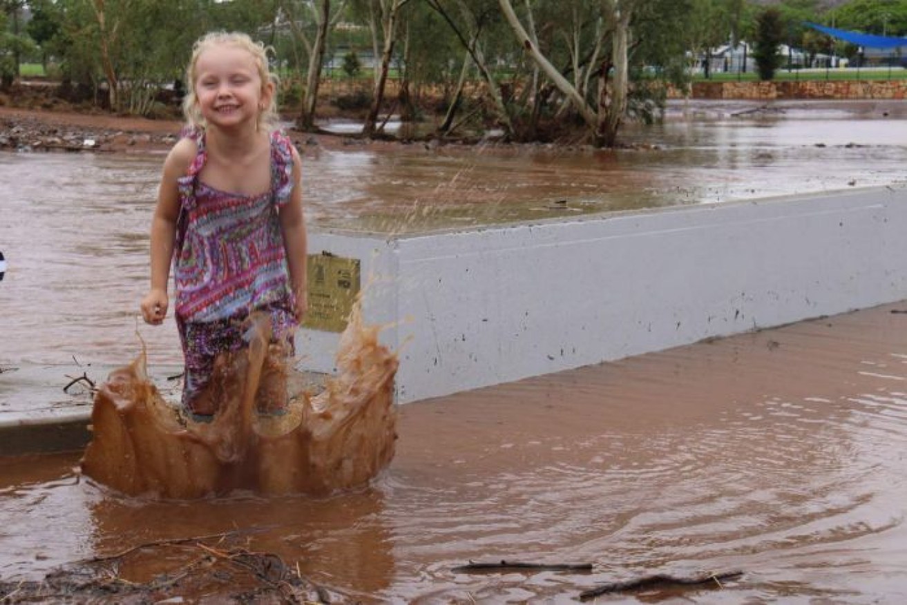 Five-year-old Taylor Galindo celebrates the rain in Mount Isa.