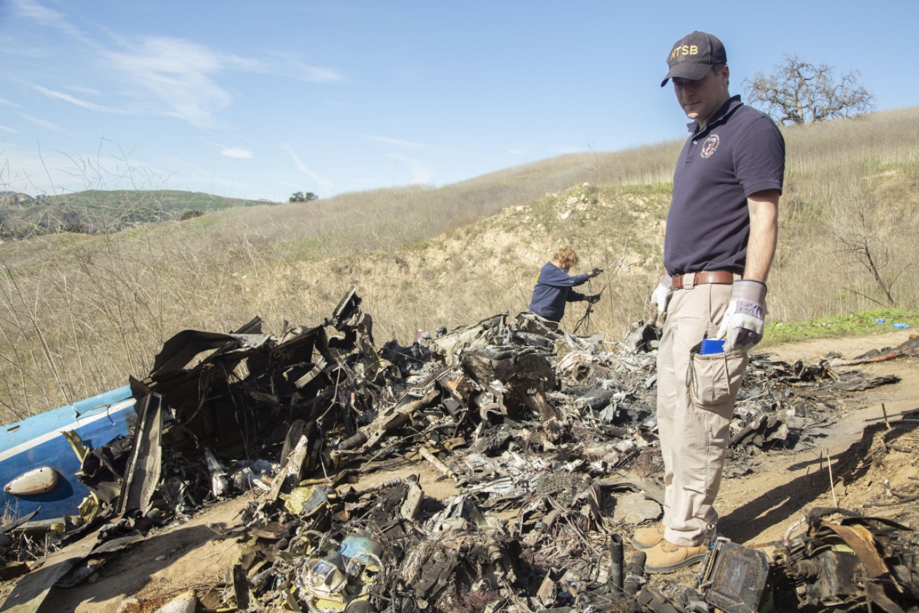 Investigators Adam Huray and Carol Hogan examining wreckage from the helicopter crash.