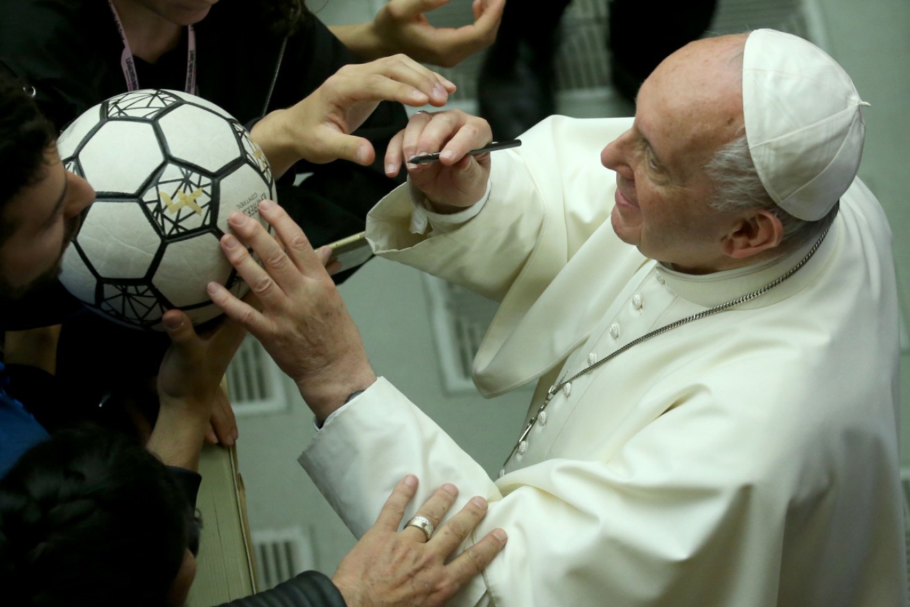 Straight to their poolroom:  Pope Francis signs a ball during an audience with Italian Football Federation players.  