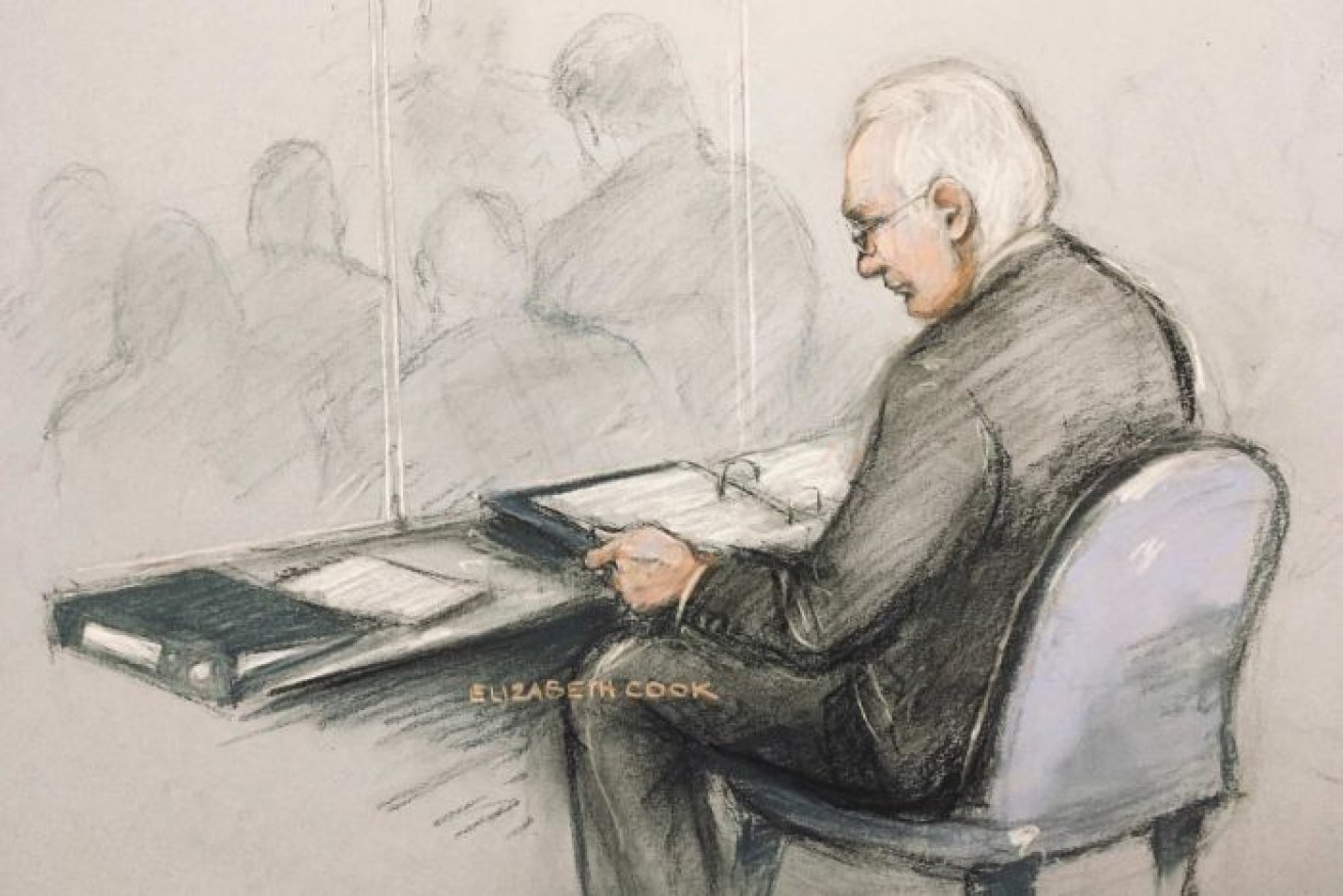 A court artist sketch of Julian Assange in the dock reading his papers at Woolwich Crown Court.