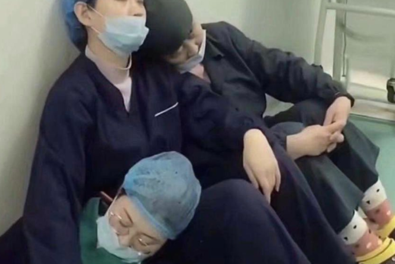 Exhausted medical staffers sleep where they slumped in a Wuhan hospital corridor.