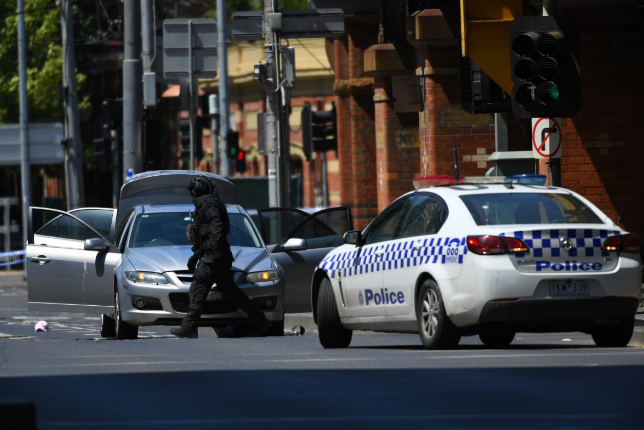 Police search the man's car after Wednesday's CBD incident.