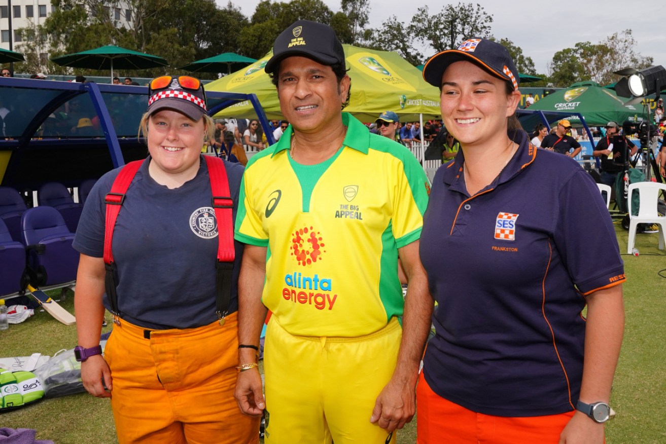 Sachin Tendulkar poses with two firefighters in Melbourne.