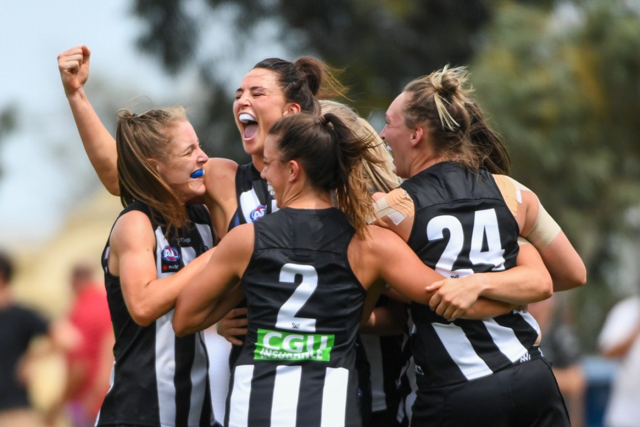 Collingwood players celebrate a goal.