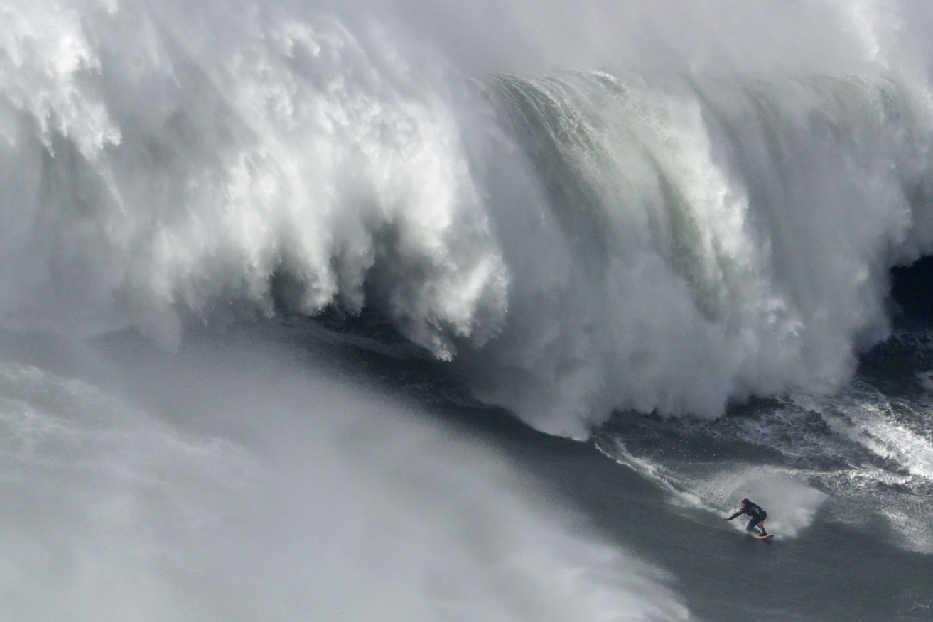 Alex Botelho rides a massive wave during the challenge at Nazare.