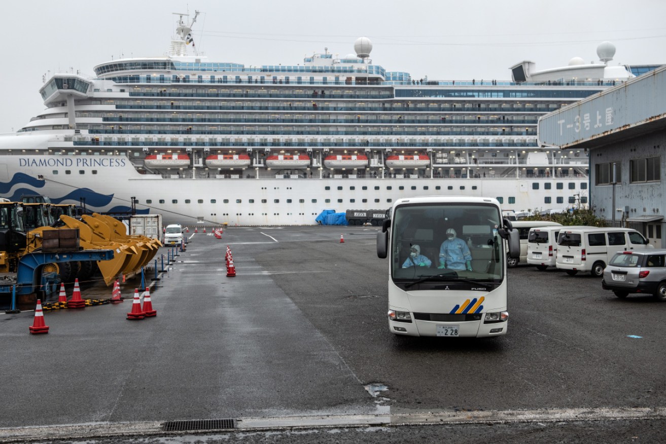 A bus leaves the quarantined <i>Diamond Princess</i> cruise ship at Yokohama, Japan. 