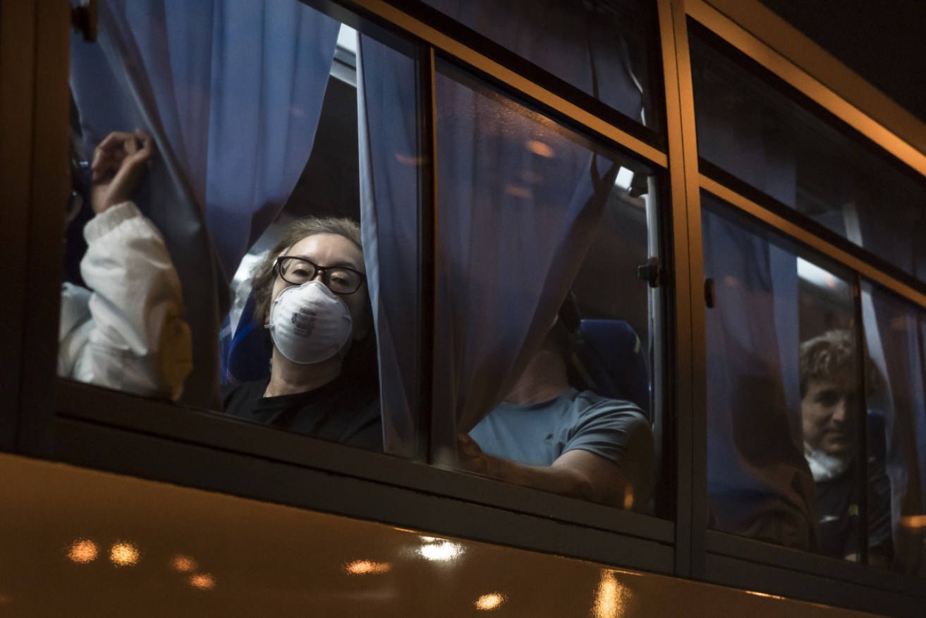 Americans from the Diamond Princess board a bus to take them to a charter flight home.