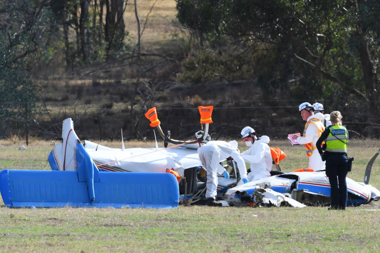 Emergency services personnel surround one of the downed planes on Wednesday.