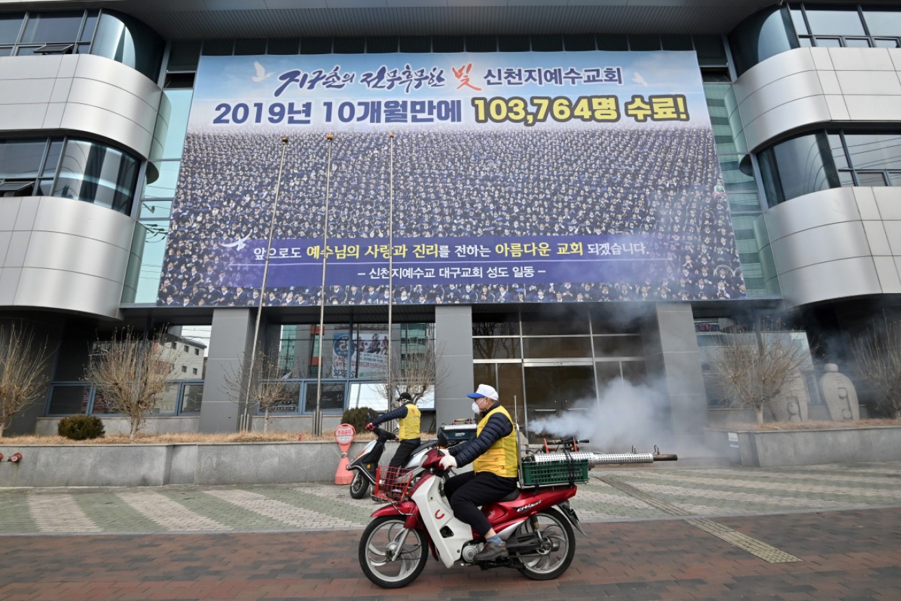 South Korean health officials spray 
spray disinfectant in front of the Daegu branch of the Shincheonji Church of Jesus.