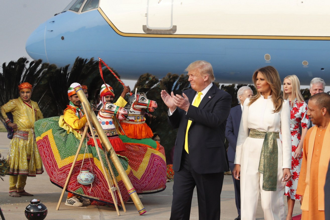 Donald Trump, accompanied by wife Melania, applauds performing artists as he arrives in Agra.