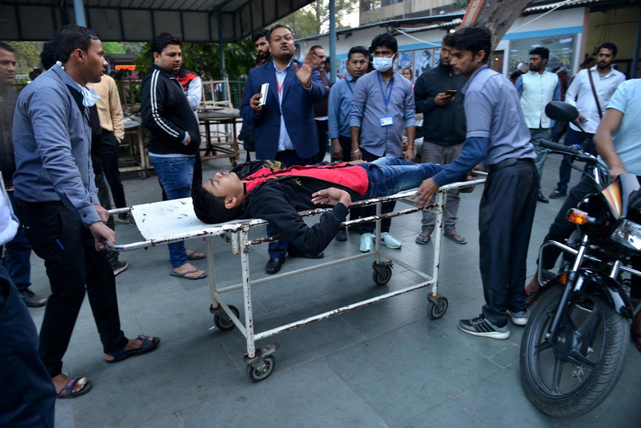One of the injured is brought to the city hospital after riots broke out in eastern Delhi.