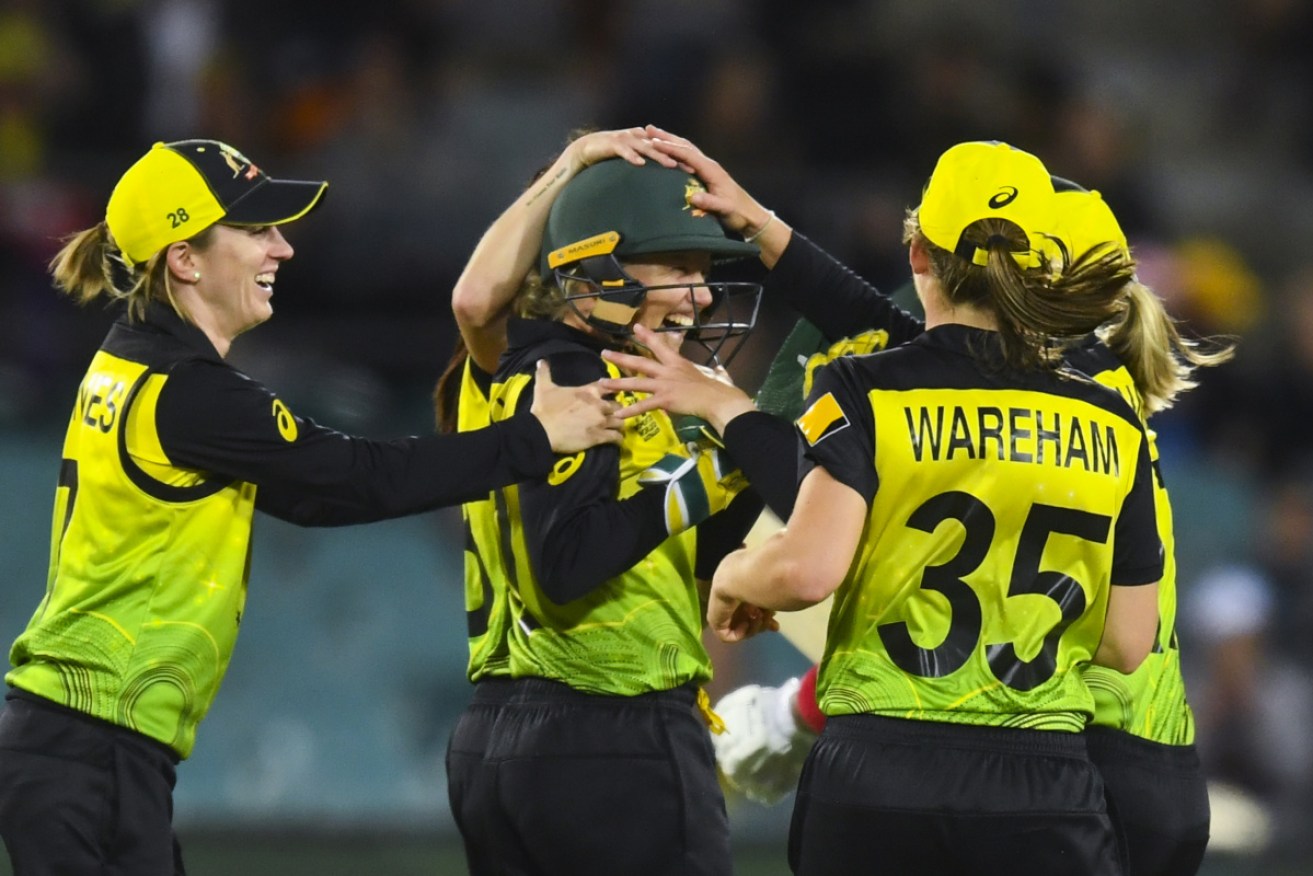 Alyssa Healy is mobbed by teammates after the wicket of Bangladesh's Fargana Hoque Pinky at Manuka Oval on Thursday night. 