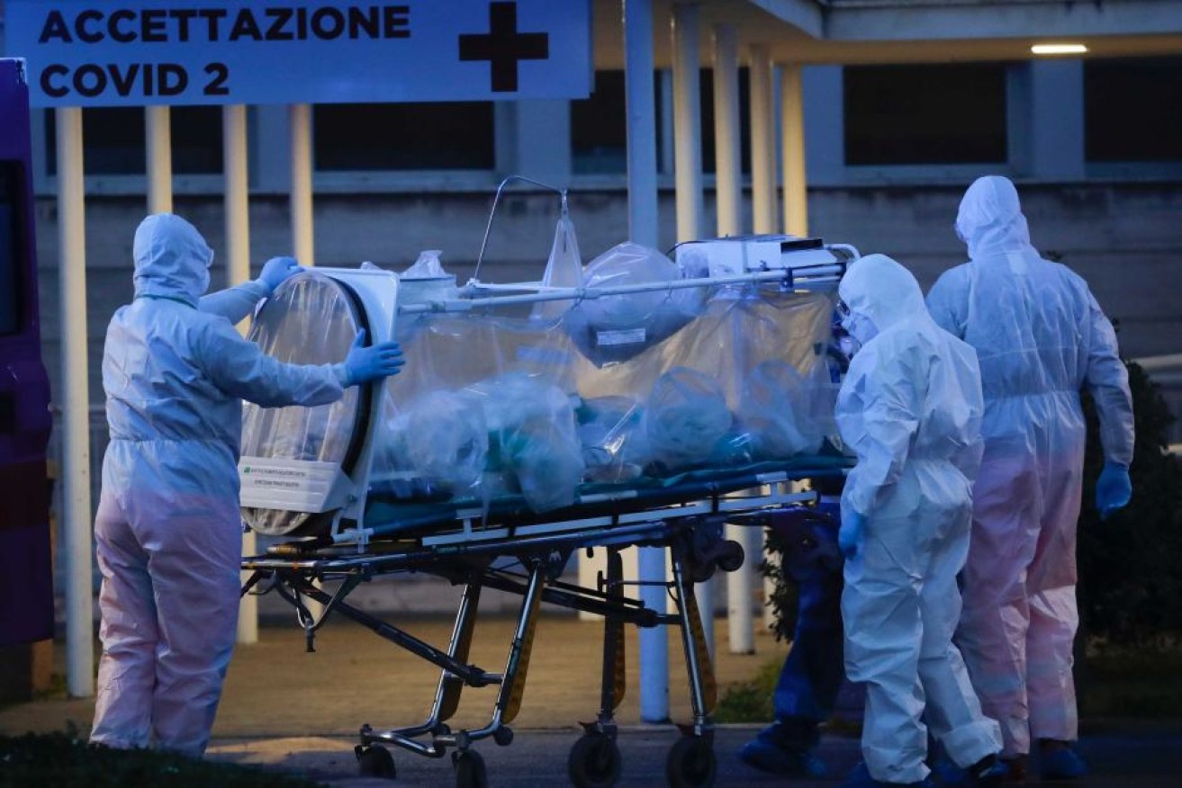 A patient in a biocontainment unit is carried on a stretcher at a makeshift coronavirus hospital in Rome.
