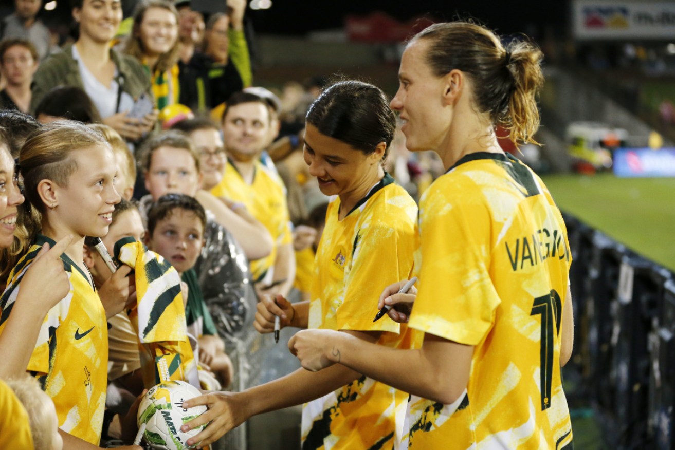 Sam Kerr and Emily van Egmond of the Matildas sign autographs after the match at Newcastle. 