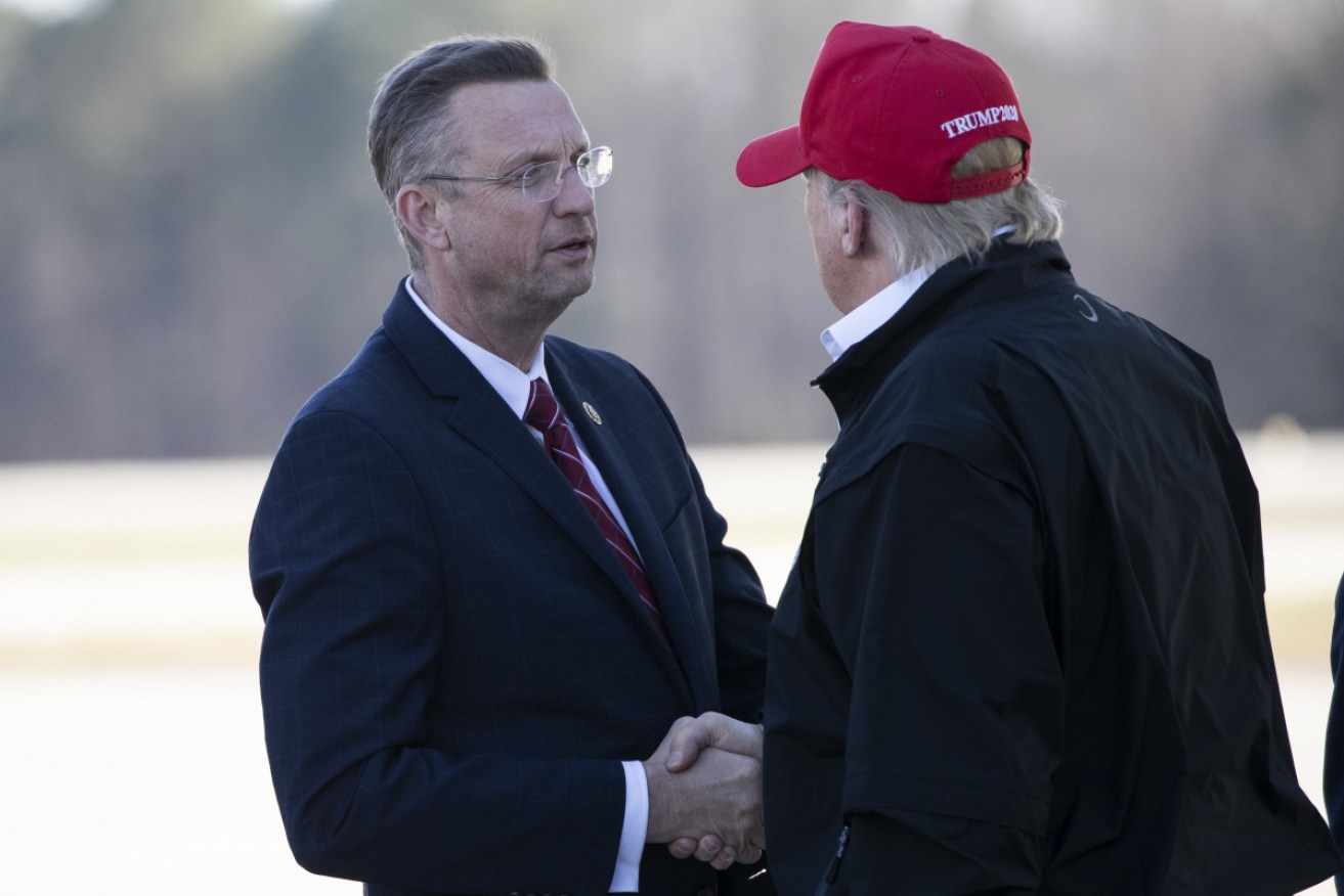 Donald Trump and Doug Collins greet each other on Friday. Mr Collins has since gone into coronavirus quarantine.