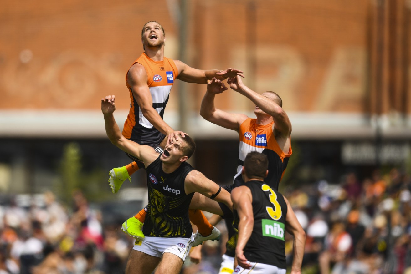 Harrison Himmelberg of the Giants (left) flies high during the match against the Tigers at Wagga Wagga. 