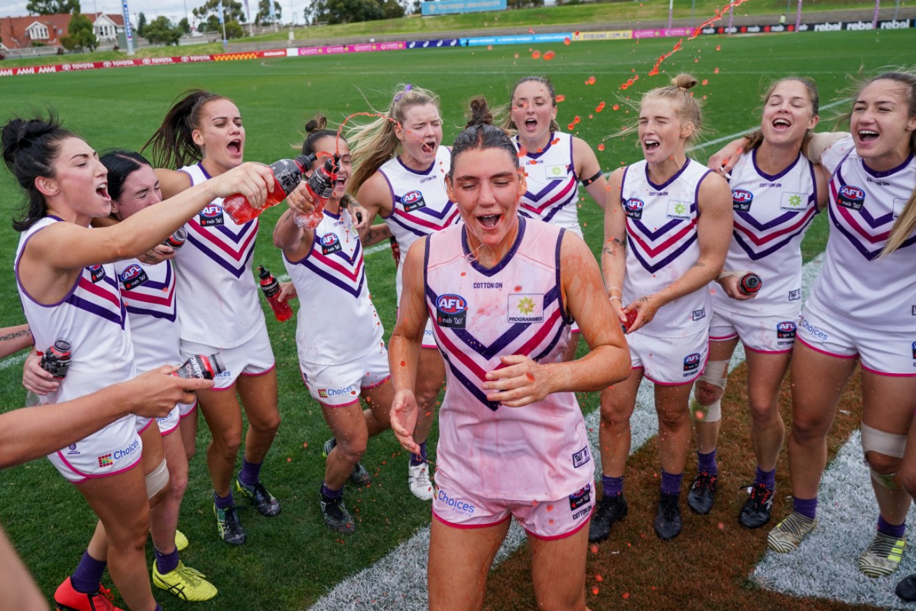 The Dockers players celebrate after keeping their perfect AFLW record intact. 