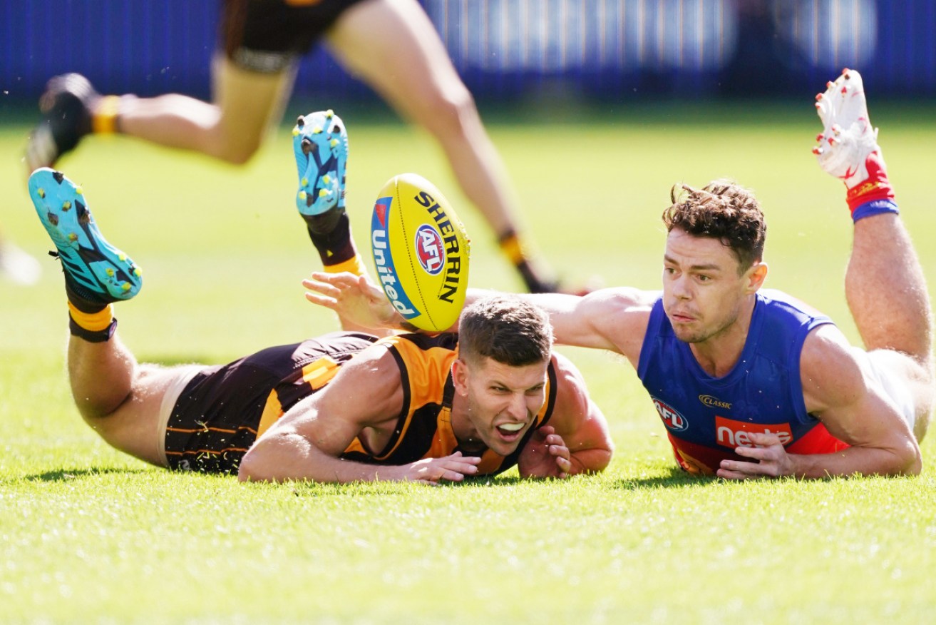 Down and out: Luke Breust of the Hawks is tackled by Lachie Neale of the Brisbane Lions at the MCG. 