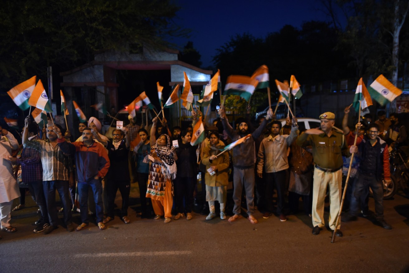 Supporters celebrate as they gather outside the gates of Tihar jail.
