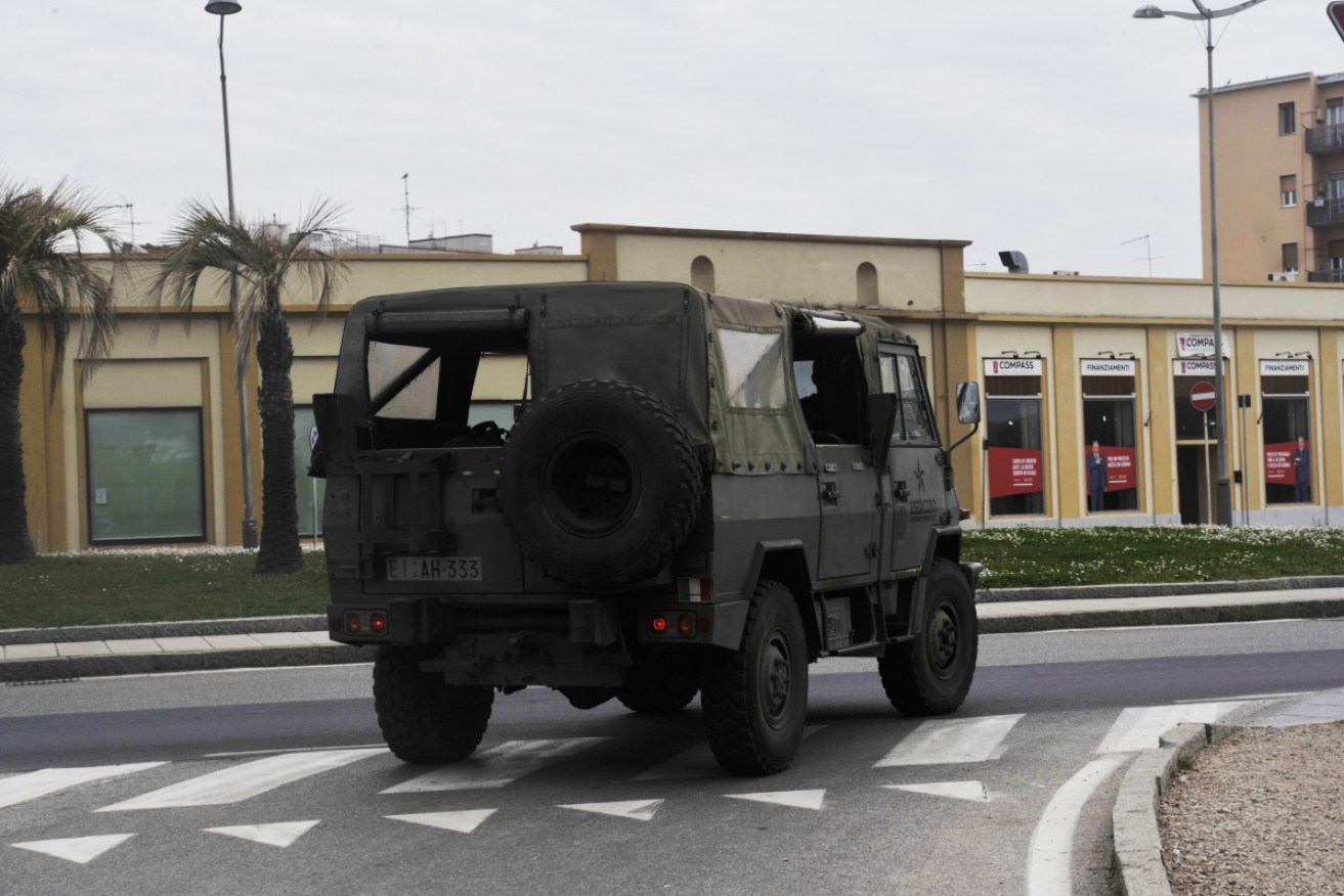 A military vehicle patrols the streets in a deserted town in Livorno,
