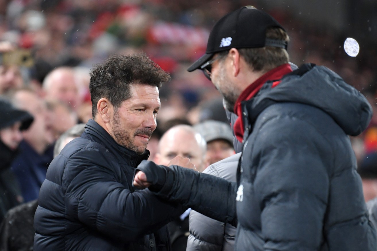 Jurgen Klopp (right) greets Atletico Madrid manager Diego Simeone with a fist bump on Wednesday.