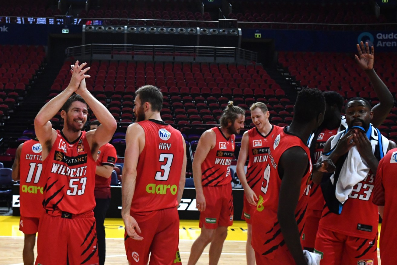 Wildcats players celebrate after winning Game 3 of the NBL finals series in Sydney on Sunday.