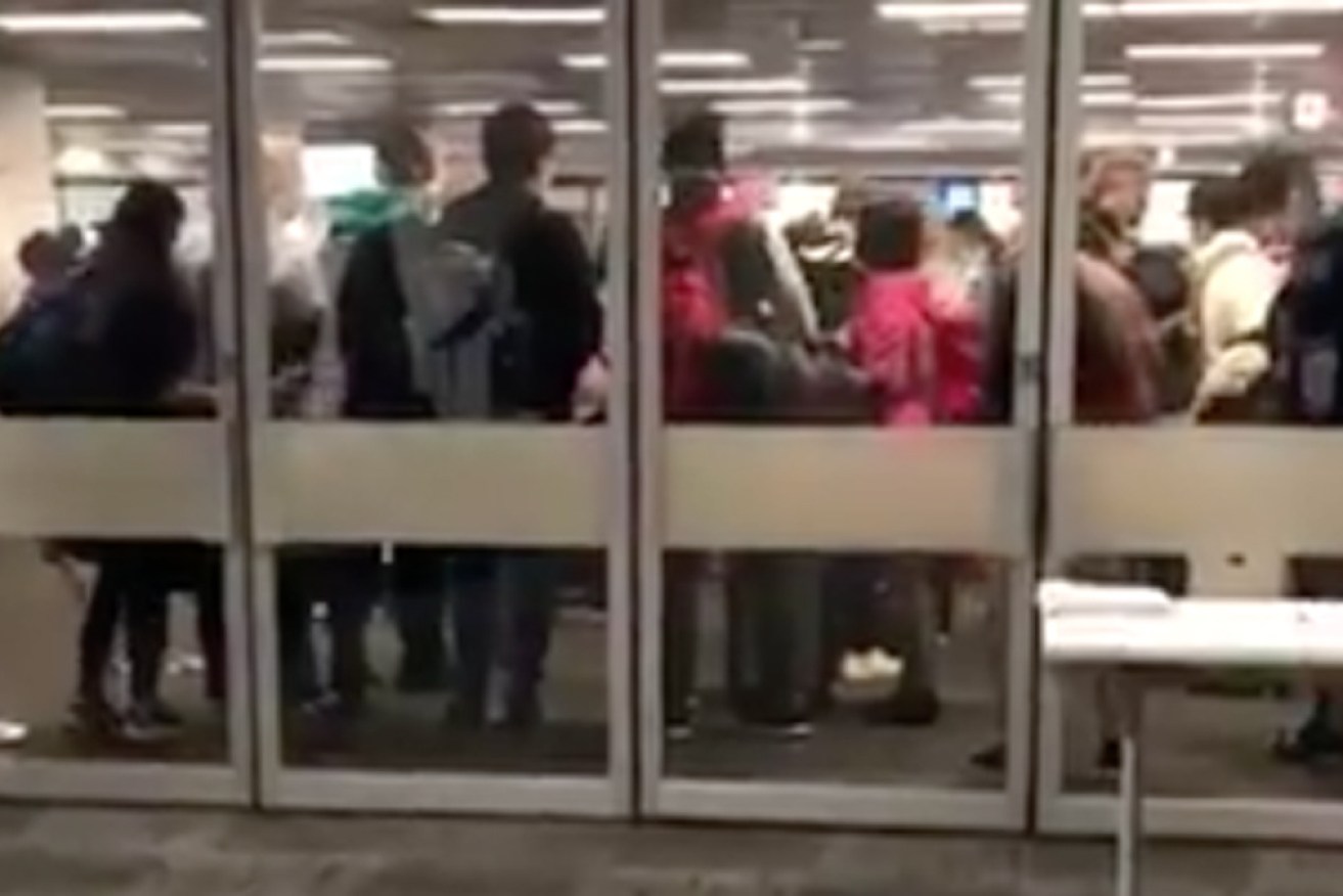 Arriving passengers crowd around a COVID-19 testing station at Sydney airport on Thursday.